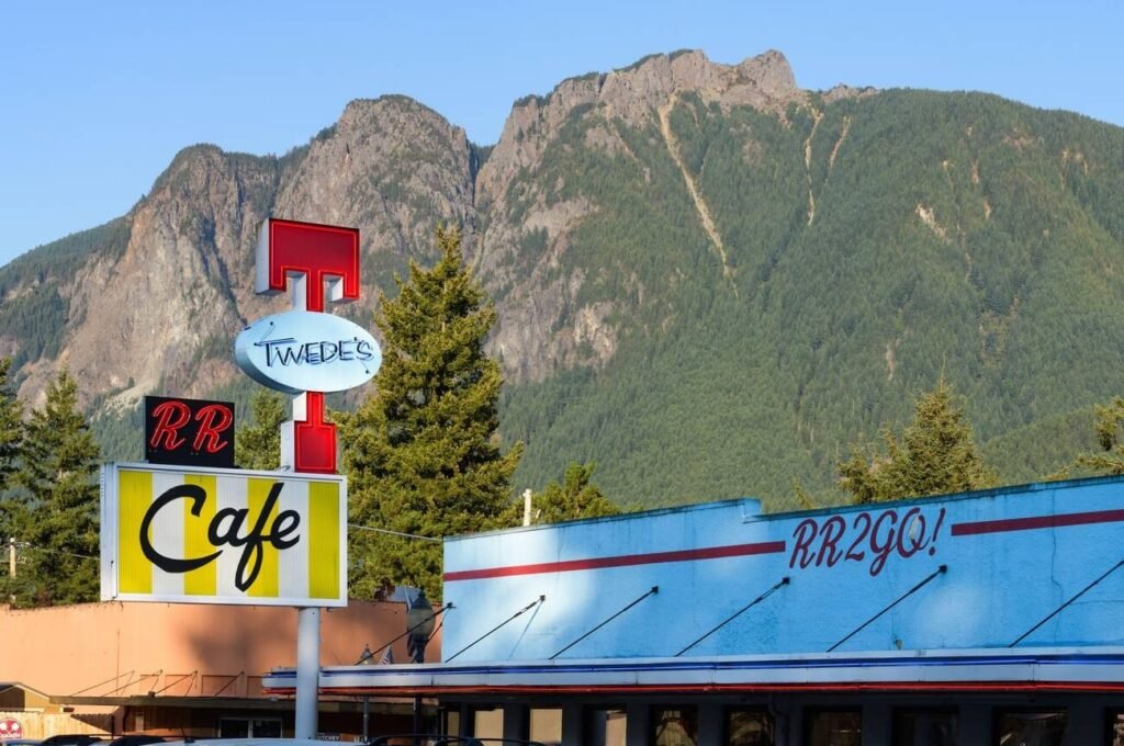 The iconic sign for Twede's Cafe (the "RR Diner" from Twin Peaks) in Snoqualmie, Washington, with a large mountain in the background.