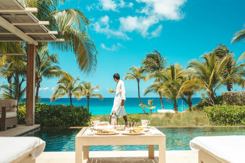 A man in a white robe enjoying breakfast at a luxury villa with a private pool overlooking Shoal Bay, Anguilla.