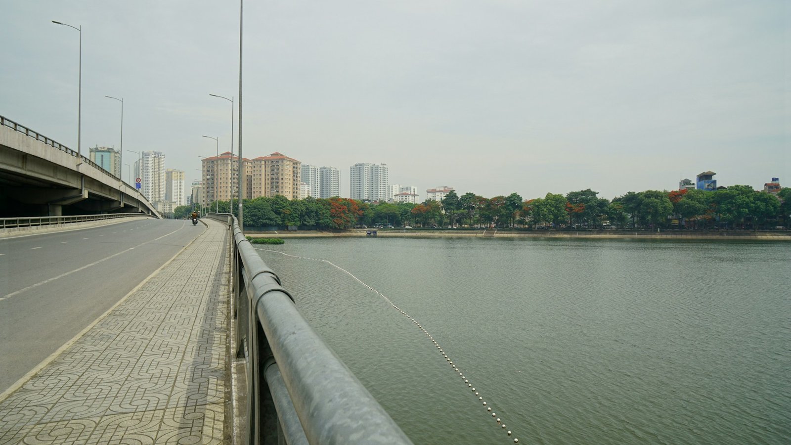 A wide urban river with a bridge on the left, modern city buildings in the background, and green trees along the right bank, representing the revitalized Pasig River in Manila.