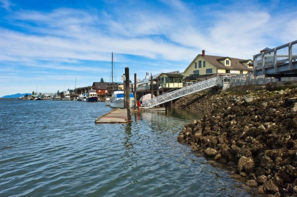 A view of the waterfront town of La Conner, Washington, from the Swinomish Channel, showing boats docked and waterfront buildings.
