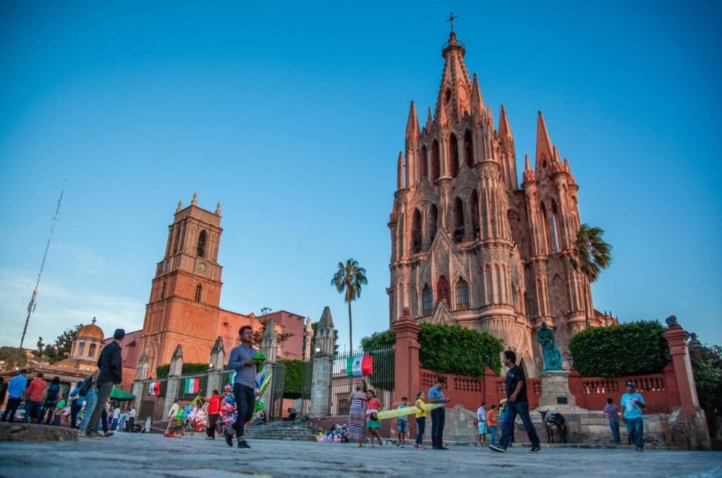 The iconic pink Parroquia de San Miguel Arcángel church in the main square of San Miguel de Allende, Mexico, at sunset.Best Cities in Mexico