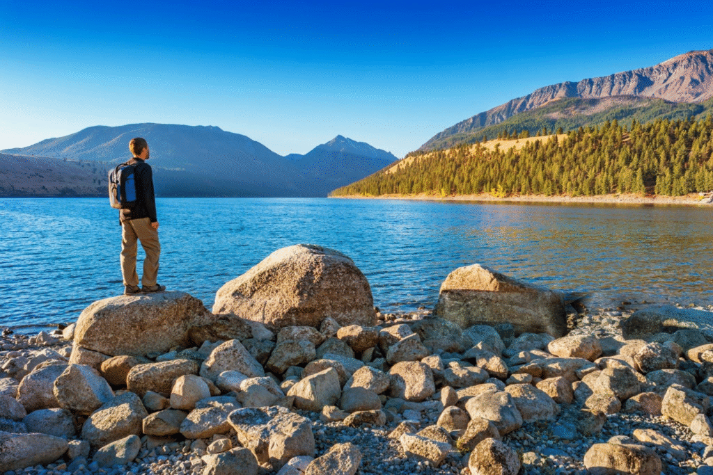 Panoramic view of Wallowa Lake and mountain peaks near Joseph, Oregon, with wildflowers in foreground.
