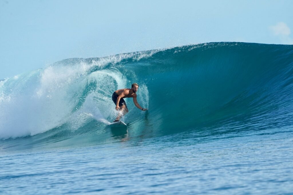 A surfer riding inside the barrel of a large, perfect, glassy blue wave on the Pacific coast of El Salvador.