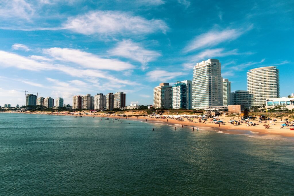 A view of the beach and modern high-rise buildings in the resort city of Punta del Este, Uruguay, on a sunny day.