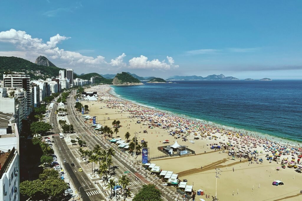 South American Countries : An aerial view of the crowded Copacabana Beach in Rio de Janeiro, Brazil, with Sugarloaf Mountain in the background.
